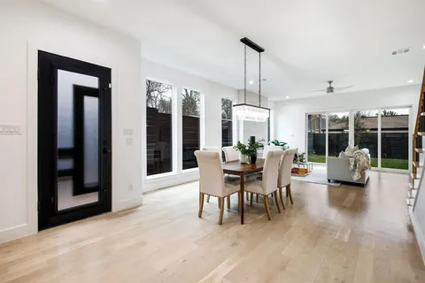 a dining room with furniture a chandelier and wooden floor