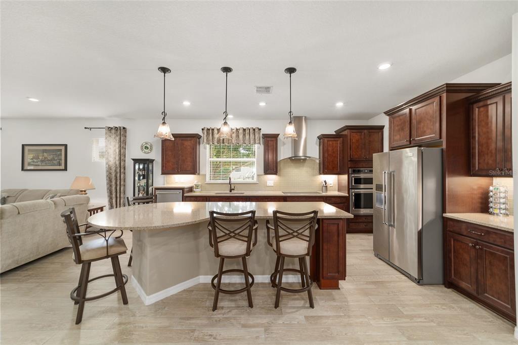 6479 Southwest 94th Circle Ocala, FL 34481 - Photo 21 of 82 a kitchen with stainless steel appliances a dining table chairs refrigerator and sink