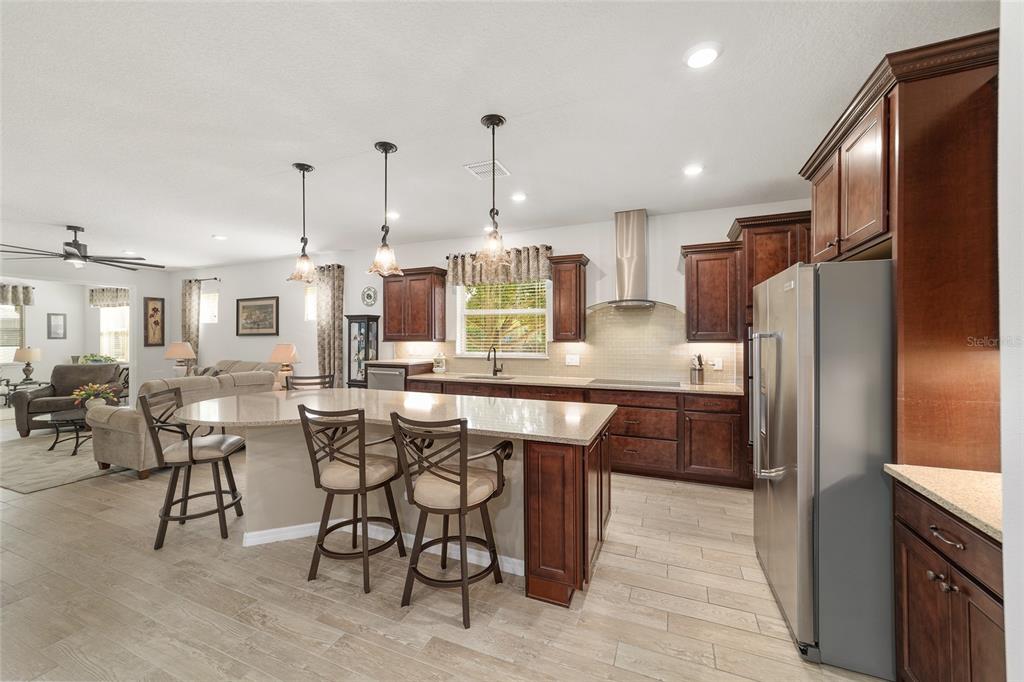 6479 Southwest 94th Circle Ocala, FL 34481 - Photo 22 of 82 a kitchen with stainless steel appliances kitchen island granite countertop a refrigerator and microwave