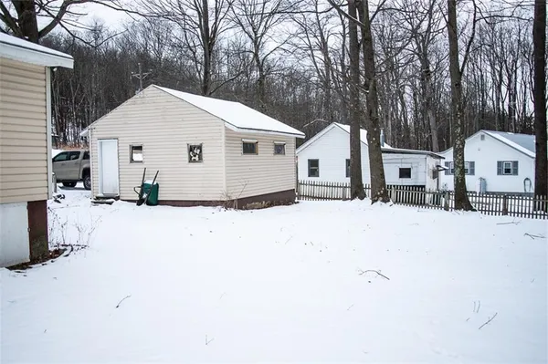 a view of a white house with a yard covered in snow
