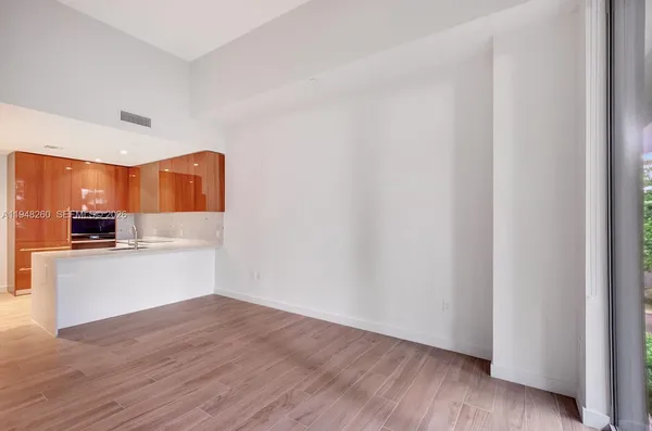 a view of a kitchen with wooden floor and electronic appliances