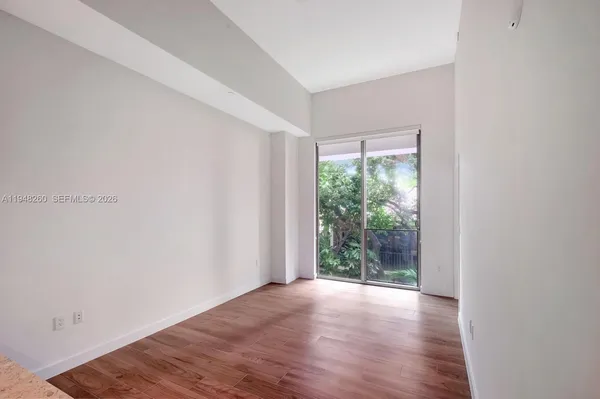 a view of a big room with wooden floor and windows