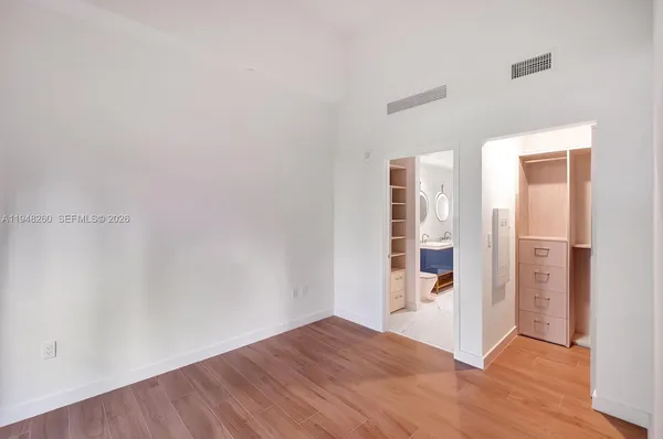 an empty room with wooden floor and entrance