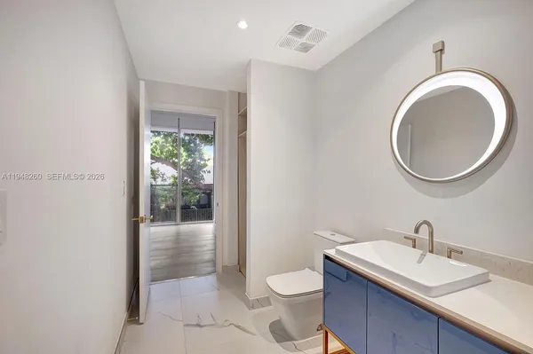 a bathroom with a toilet a sink and a mirror