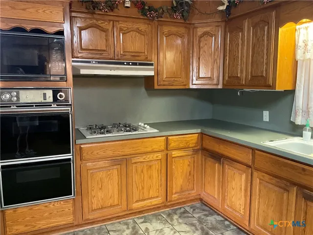 a kitchen with stainless steel appliances granite countertop a stove and a microwave