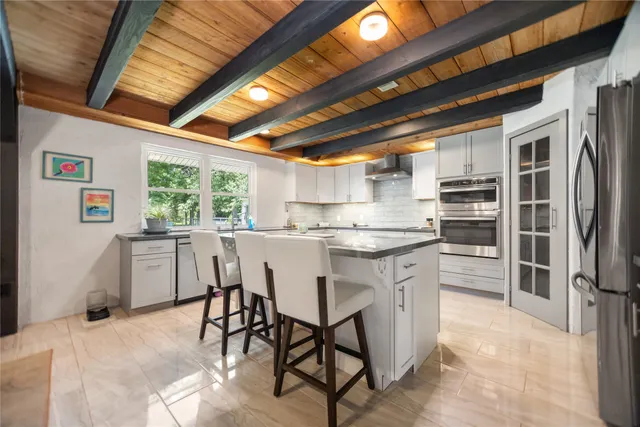 a kitchen with stainless steel appliances granite countertop a stove a sink dishwasher and a refrigerator