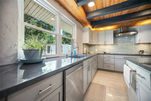 a kitchen with a sink a counter top space cabinets and appliances