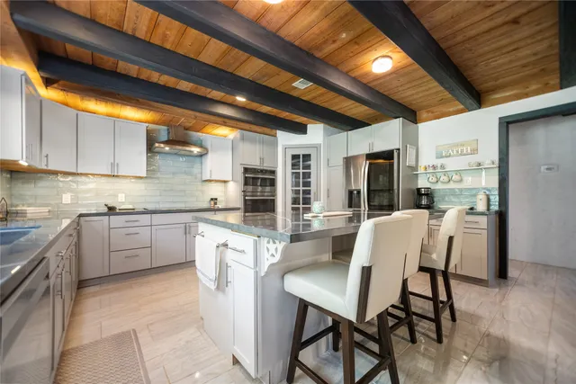 a kitchen with granite countertop white cabinets and stainless steel appliances
