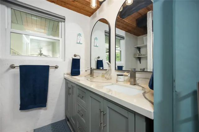 a bathroom with a granite countertop sink a toilet and shower