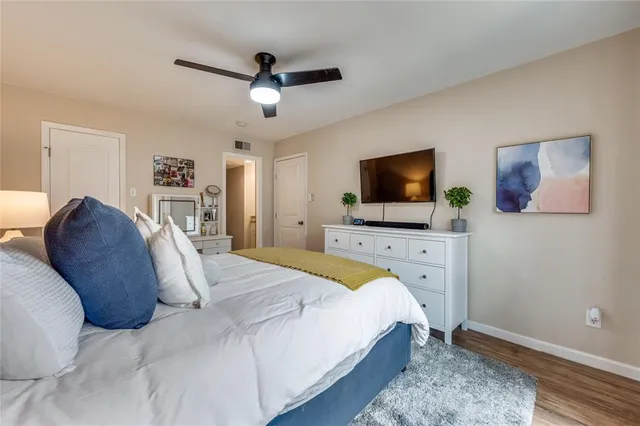 a bedroom with a bed flat screen tv and a window