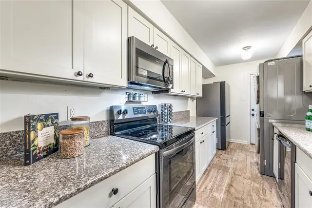 a kitchen with stainless steel appliances granite countertop a stove refrigerator and microwave