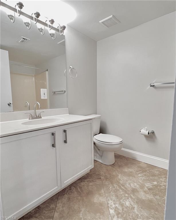 481 Quail Forest Boulevard, Unit B206 Naples, FL 34105 - Photo 11 of 16 a bathroom with a toilet sink and mirror