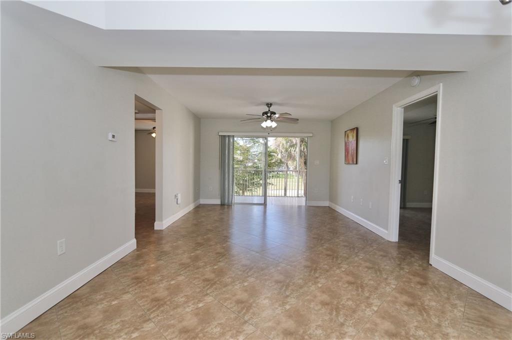 481 Quail Forest Boulevard, Unit B206 Naples, FL 34105 - Photo 3 of 16 a view of a big room with windows and chandelier fan