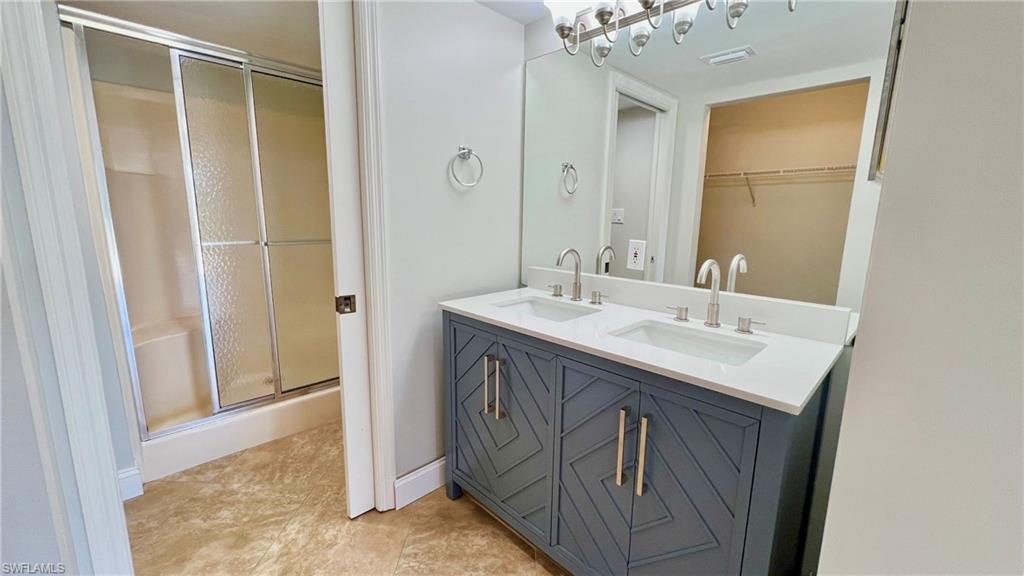 481 Quail Forest Boulevard, Unit B206 Naples, FL 34105 - Photo 8 of 16 a bathroom with a sink a vanity and a mirror