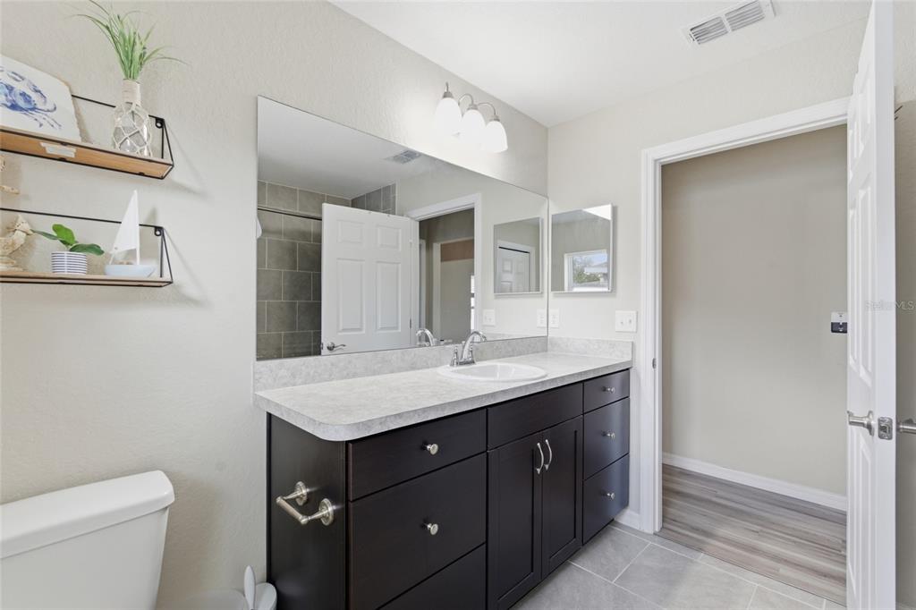 13880 Southwest 45th Terrace Ocala, FL 34473 - Photo 12 of 19 a bathroom with a granite countertop sink a toilet and a mirror