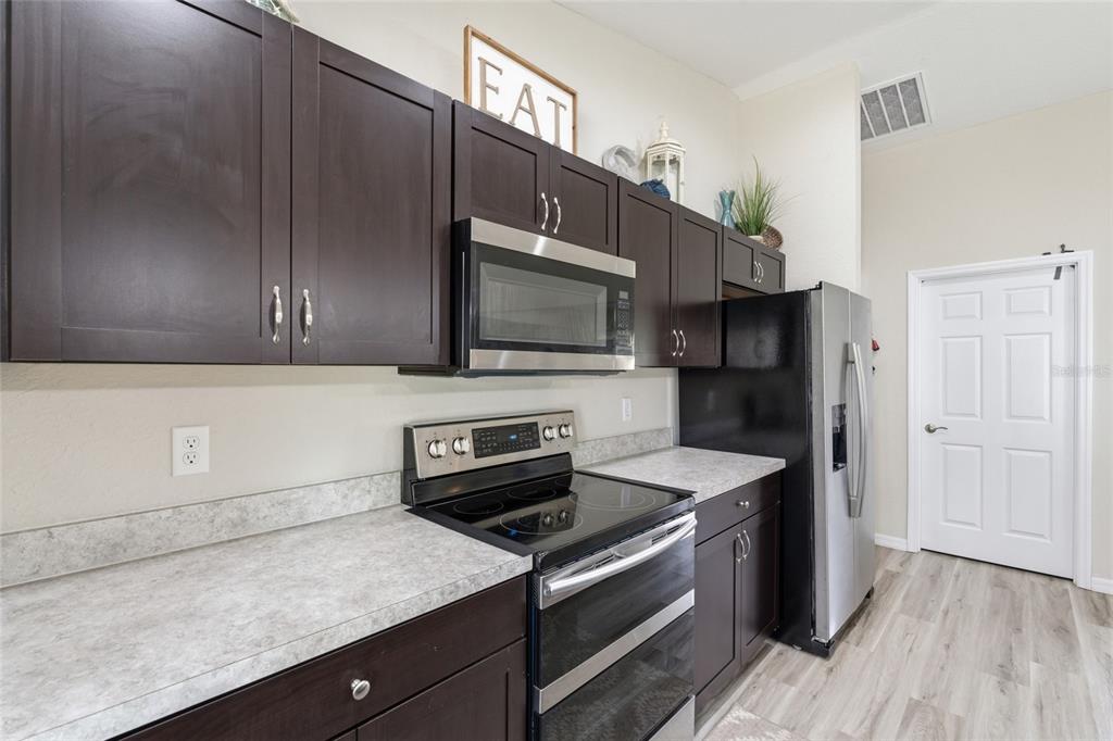 13880 Southwest 45th Terrace Ocala, FL 34473 - Photo 7 of 19 a kitchen with stainless steel appliances a stove microwave and sink
