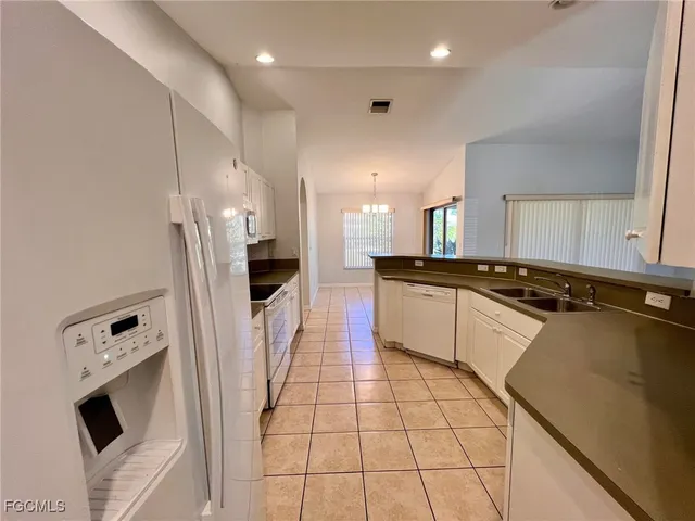 a large kitchen with a stove a refrigerator and a sink