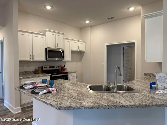 a kitchen with kitchen island granite countertop a sink cabinets and window