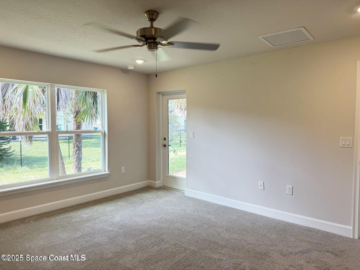 366 Faith Terrace Sebastian, FL 32958 - Photo 9 of 19 an empty room with a ceiling fan and windows