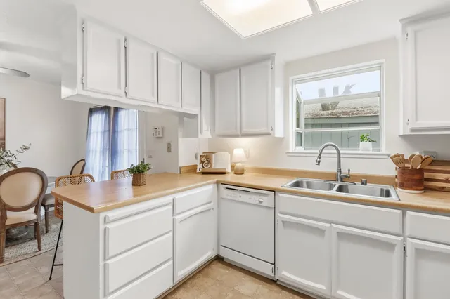 a kitchen with cabinets appliances a sink and a window