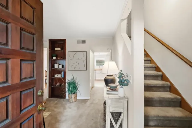 a view of staircase with lots of frames on wall and a potted plant