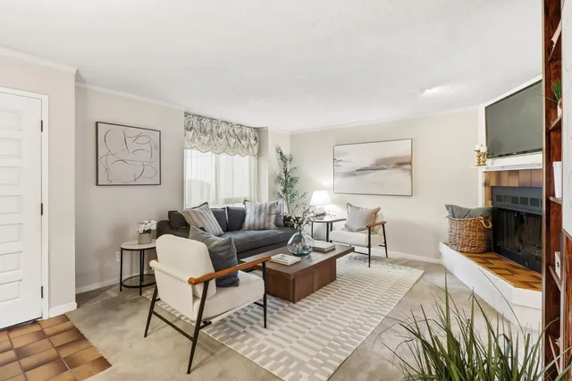 a living room with furniture a flat screen tv and a fireplace