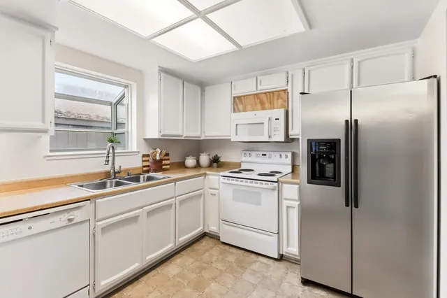 a kitchen with white cabinets and white stainless steel appliances
