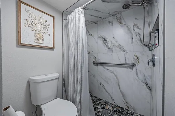 a white toilet sitting next to a shower curtain