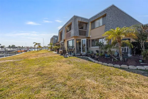 a front view of house with yard and ocean
