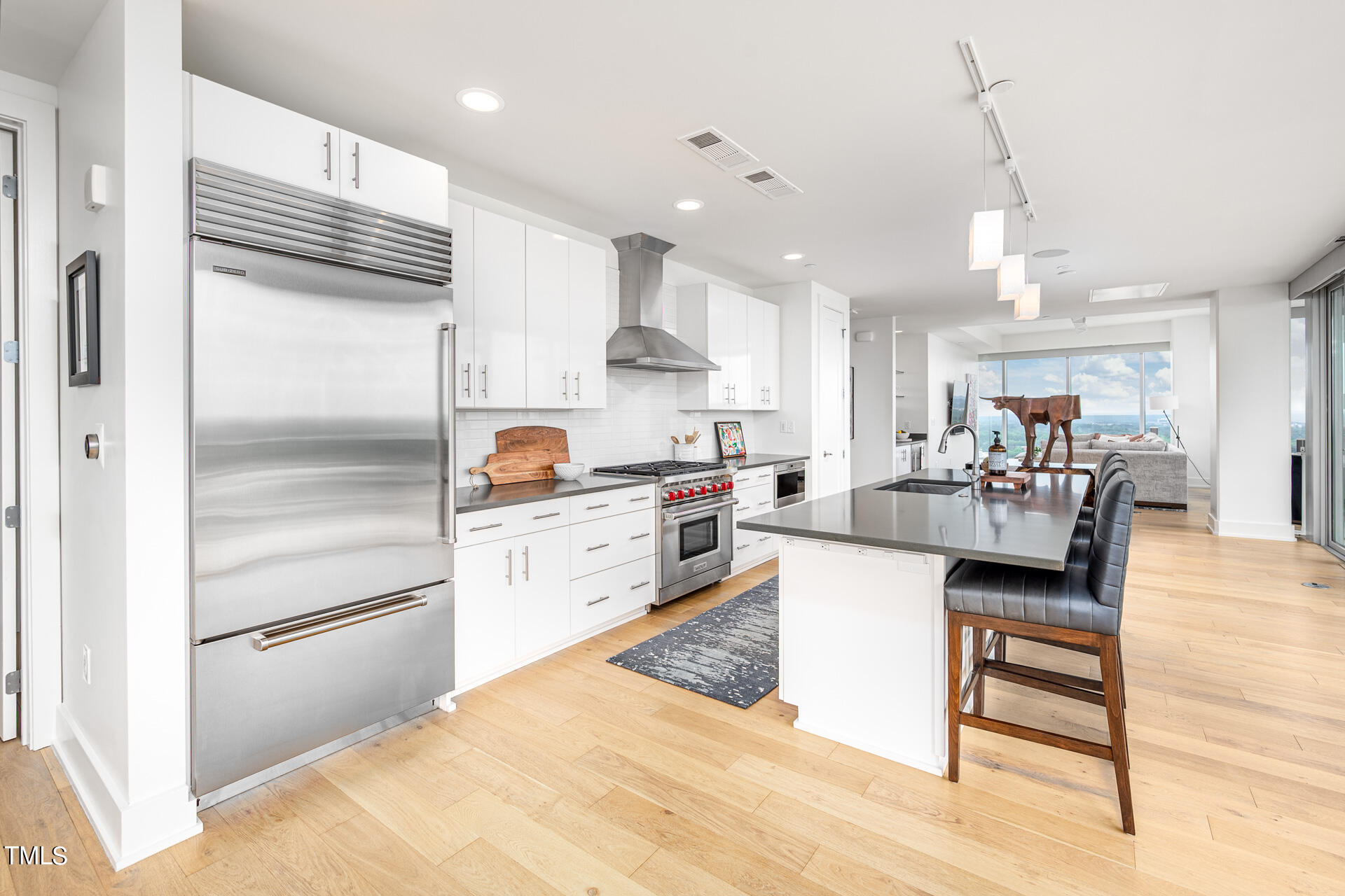 110 Corcoran Street, Unit 2301 Durham, NC 27701 - Photo 16 of 66 a kitchen with stainless steel appliances kitchen island granite countertop a refrigerator and a stove top oven
