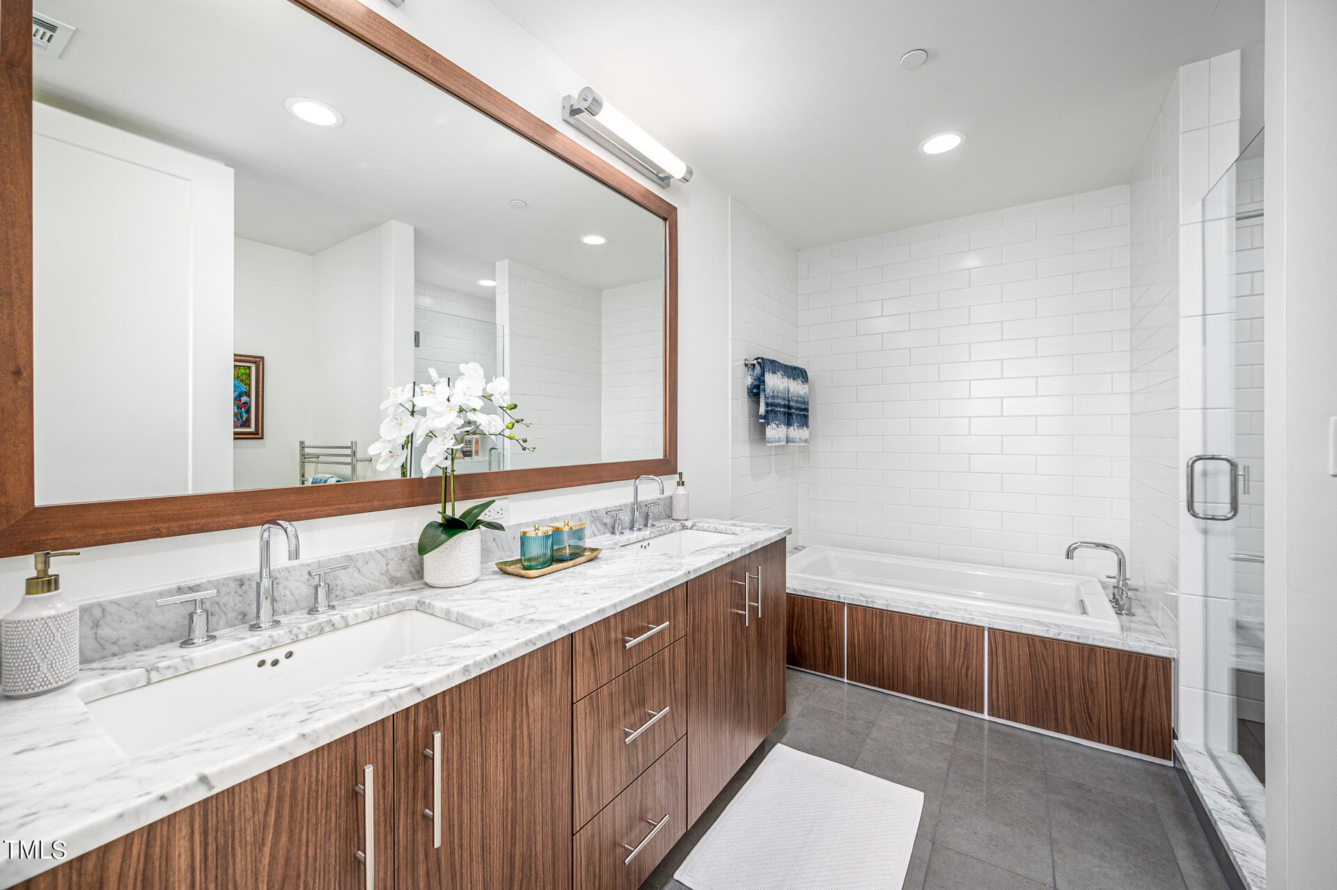 110 Corcoran Street, Unit 2301 Durham, NC 27701 - Photo 22 of 66 a bathroom with a granite countertop double vanity sink and mirror with bathtub