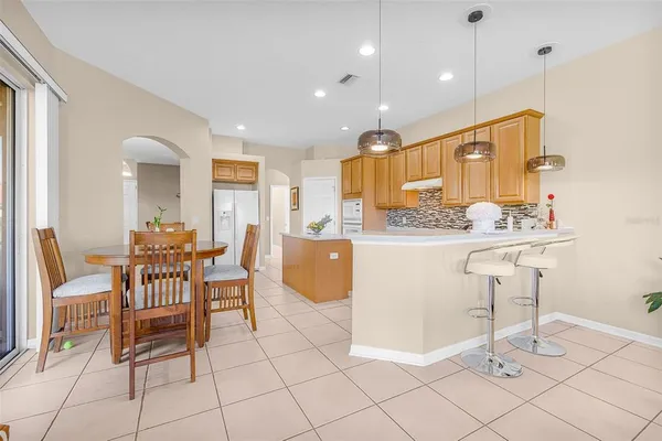 a dining room filled chandelier and kitchen view