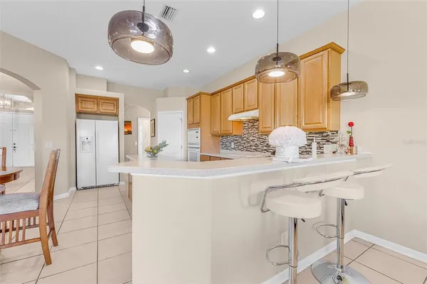 a kitchen with kitchen island a sink and a chandelier