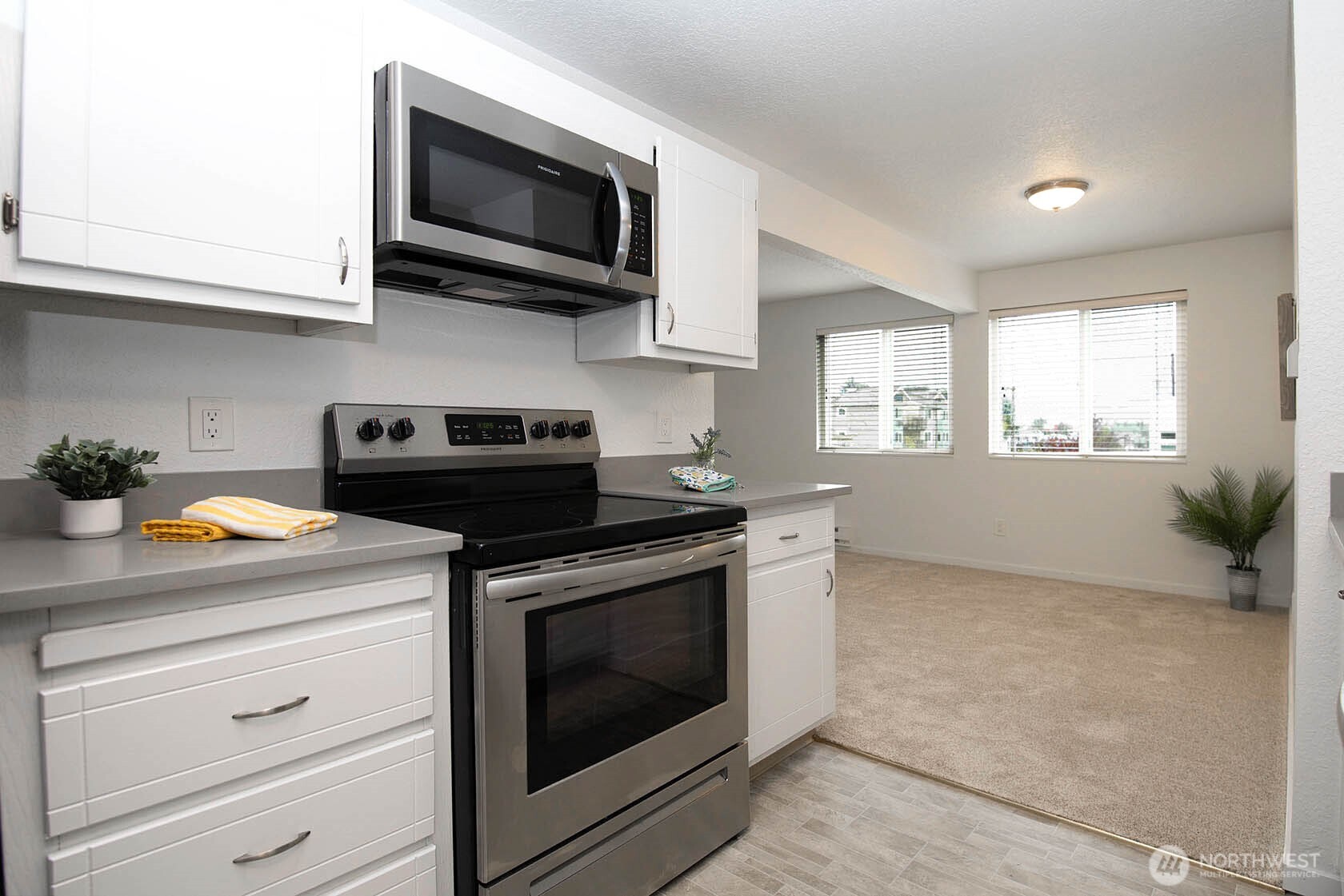8747 Phinney Avenue North, Unit 13 Seattle, WA 98103 - Photo 17 of 32 a kitchen with stainless steel appliances white cabinets granite counter tops and a window