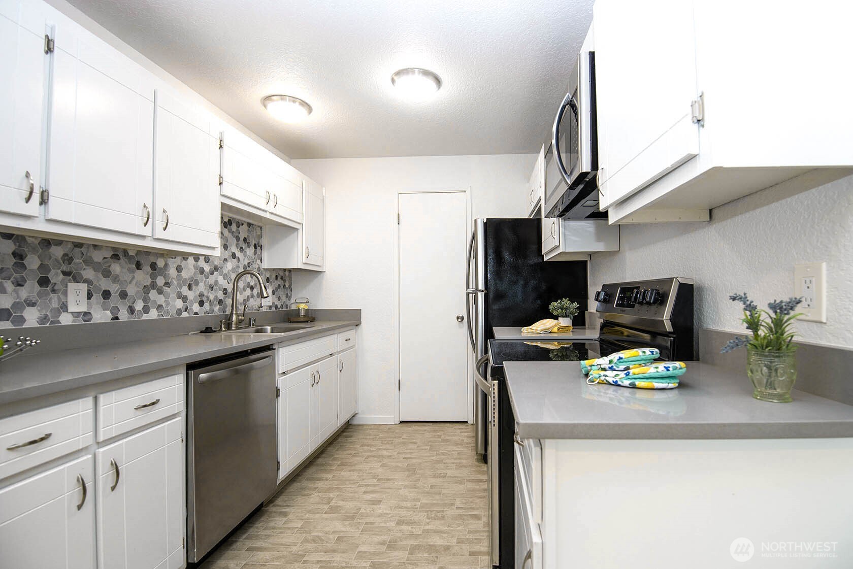 8747 Phinney Avenue North, Unit 13 Seattle, WA 98103 - Photo 18 of 32 a kitchen with granite countertop a sink and white cabinets