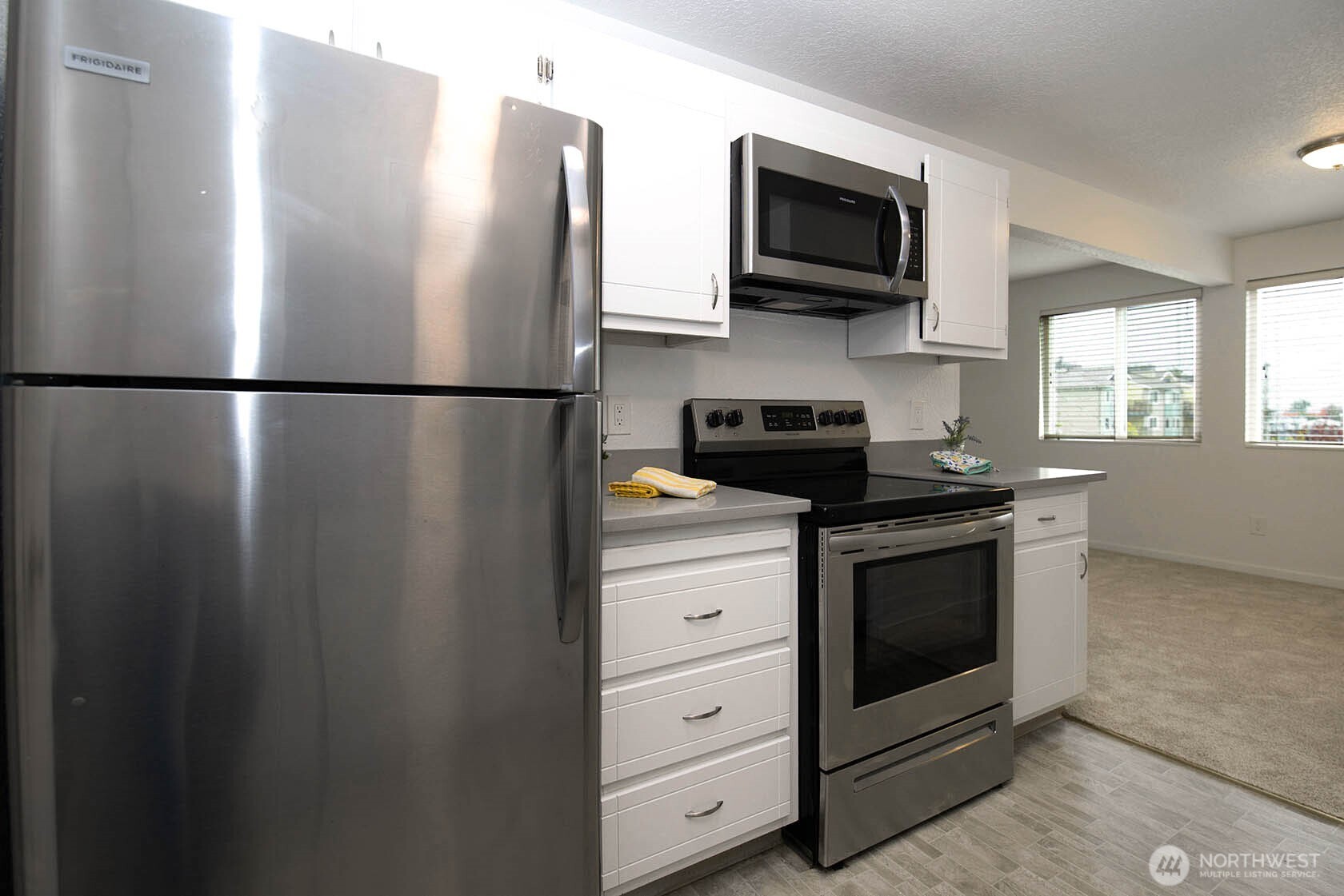 8747 Phinney Avenue North, Unit 13 Seattle, WA 98103 - Photo 20 of 32 a metallic refrigerator freezer sitting in a kitchen