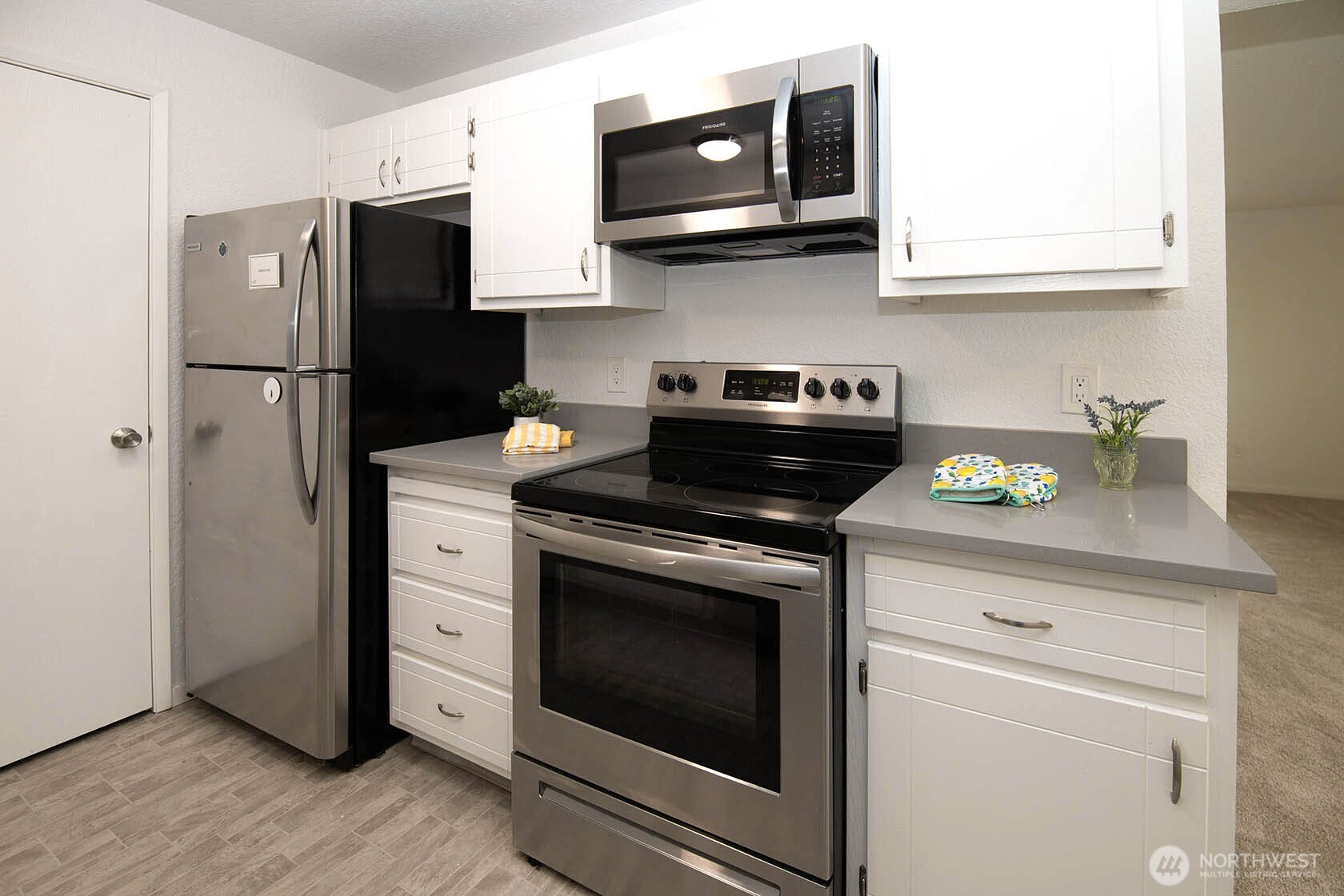 8747 Phinney Avenue North, Unit 13 Seattle, WA 98103 - Photo 21 of 32 a kitchen with stainless steel appliances granite countertop a stove microwave and refrigerator