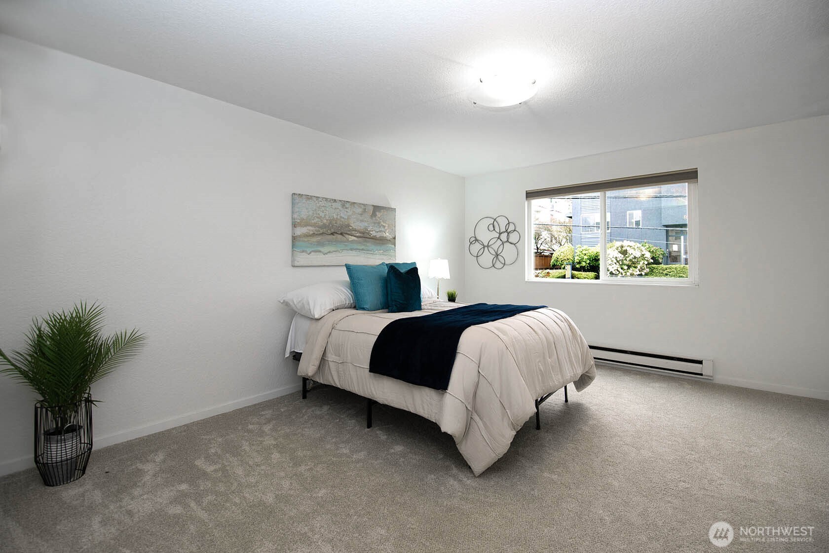 8747 Phinney Avenue North, Unit 13 Seattle, WA 98103 - Photo 7 of 32 a bedroom with a bed and a potted plant