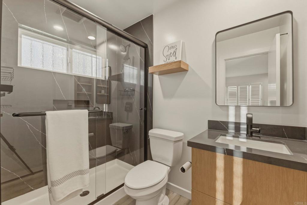 1712 Burgundy Road Encinitas, CA 92024 - Photo 20 of 31 a bathroom with a toilet a sink a mirror a vanity and shower