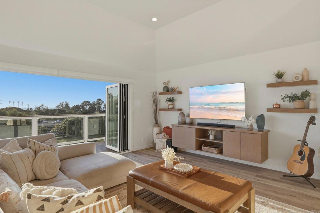 1712 Burgundy Road Encinitas, CA 92024 - Photo 3 of 31 a living room with furniture a flat screen tv and a floor to ceiling window