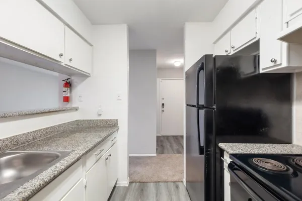 a kitchen with granite countertop a refrigerator and a sink