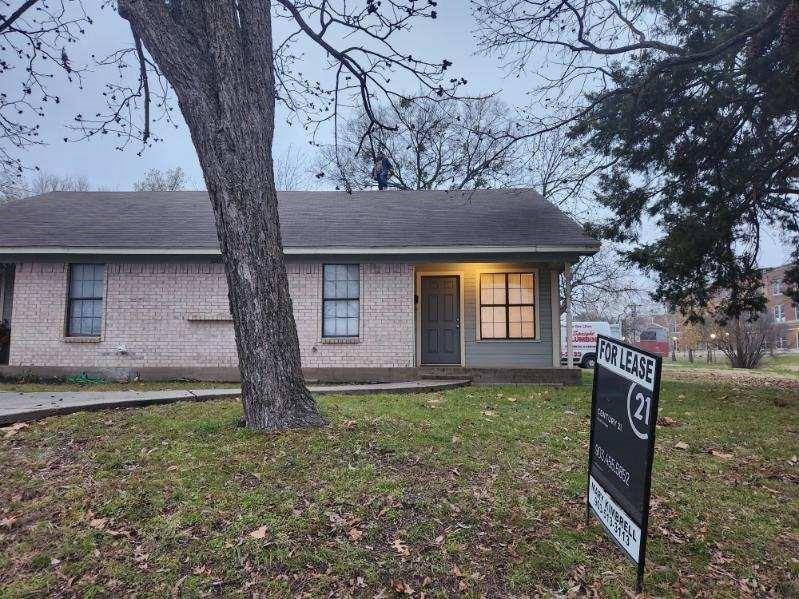 2203 Monroe Street, Unit A Commerce, TX 75428 - Photo 1 of 1 View of front of house with a shingled roof, a front lawn, and brick siding