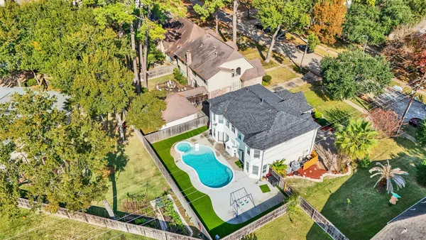 an aerial view of a house with swimming pool and garden view