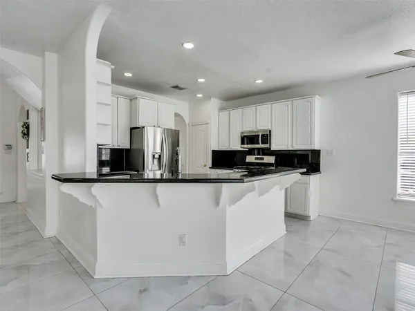 a kitchen with stainless steel appliances granite countertop a refrigerator sink and cabinets