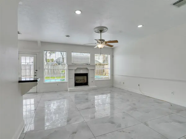 a view of empty room with a fireplace and fan