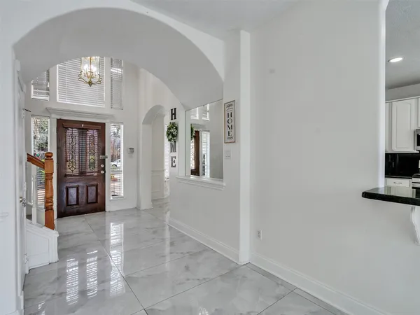 a view of a hallway with wooden floor and a living room