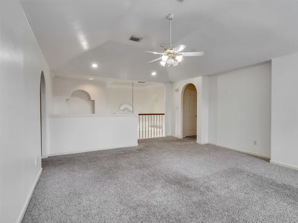 an empty room with a ceiling fan and a window