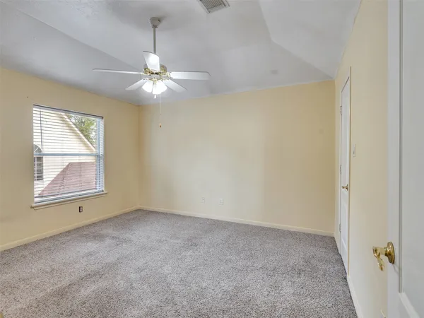 an empty room with windows and fan