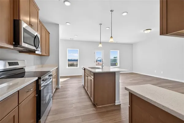 a kitchen with stainless steel appliances granite countertop a sink a stove and a wooden floors