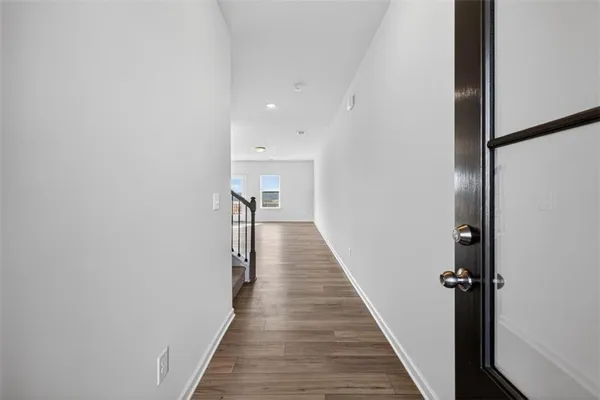 a view of a hallway with wooden floor and staircase